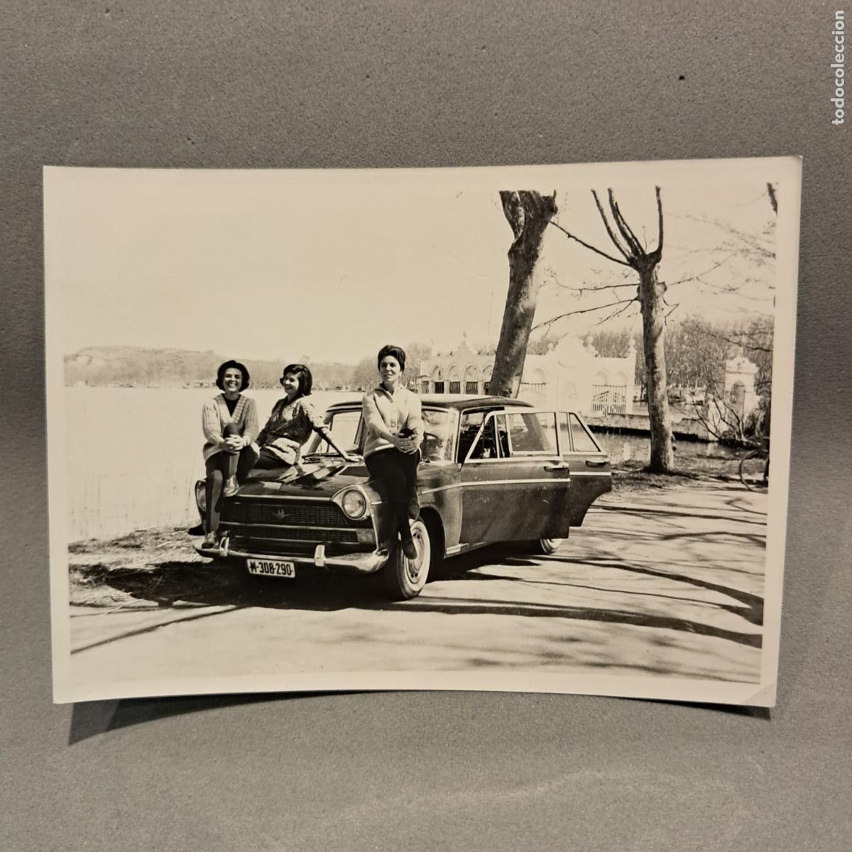 Coches a escala: Antigua Fotograf&iacute;a, chicas posando con Seat 1400 C frente Pesquera Marimon, Estany de Banyoles 1963