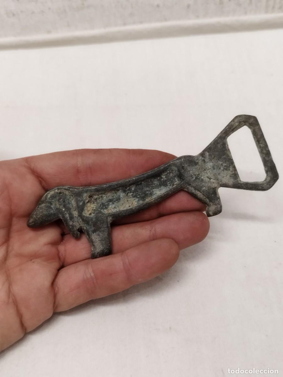 Abrebotellas y sacacorchos de colecci&oacute;n: Antiguo abridor de botellas chapas, en forma de perro. En bronce o lat&oacute;n.