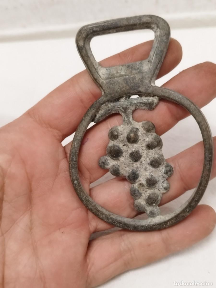 Abrebotellas y sacacorchos de colecci&oacute;n: Antiguo abridor de botellas chapas, con racimo de uvas a enderezar.. En bronce o lat&oacute;n.