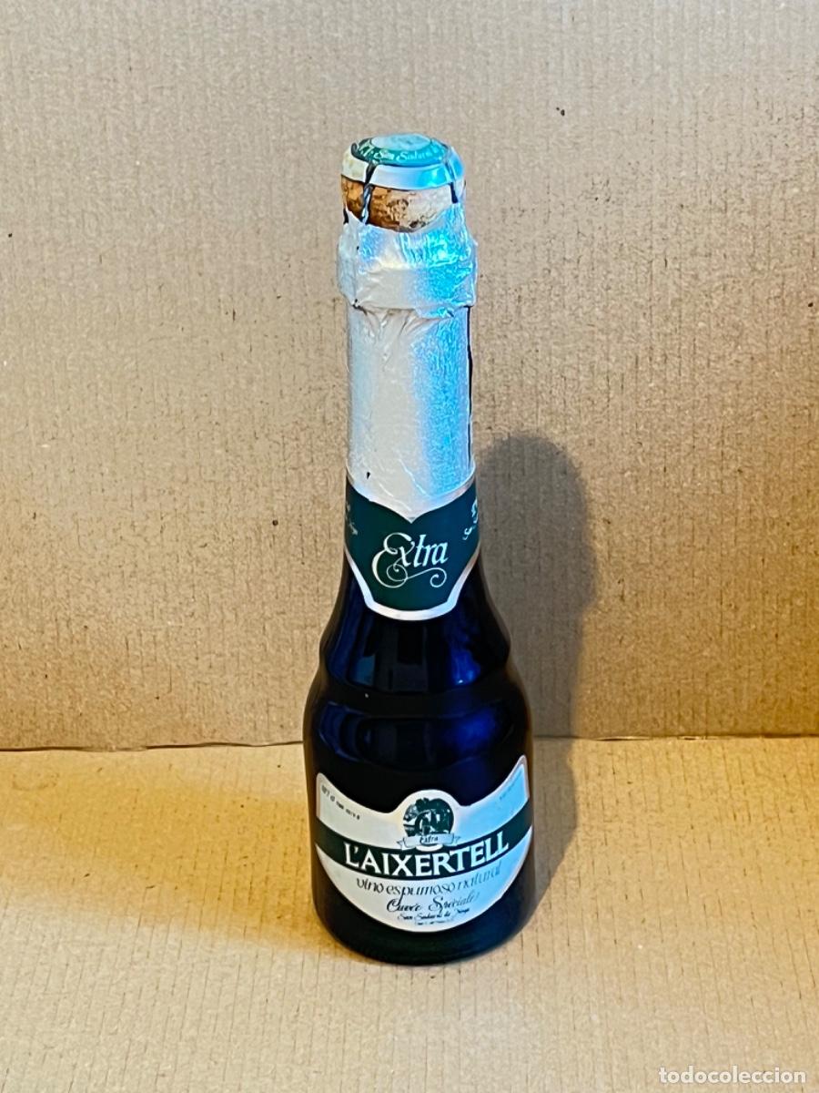 Coleccionismo de cava: MUY ANTIGUA Botella benjamin vino espumoso cava champ&aacute;n L&rsquo;AIXERTELL con placa chapa