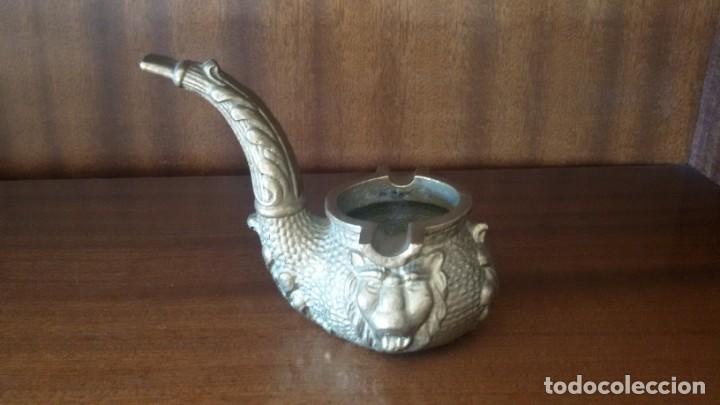 Aschenbecher: Cenicero de bronce en forma de pipa con caras de le&oacute;n.