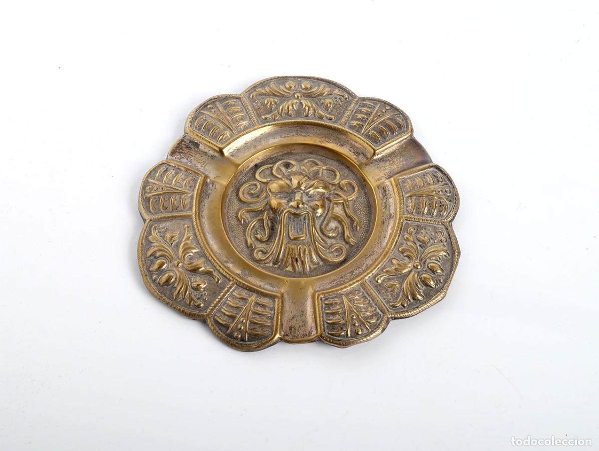 Aschenbecher: Antiguo cenicero de bronce con relieve de cabeza de le&oacute;n.