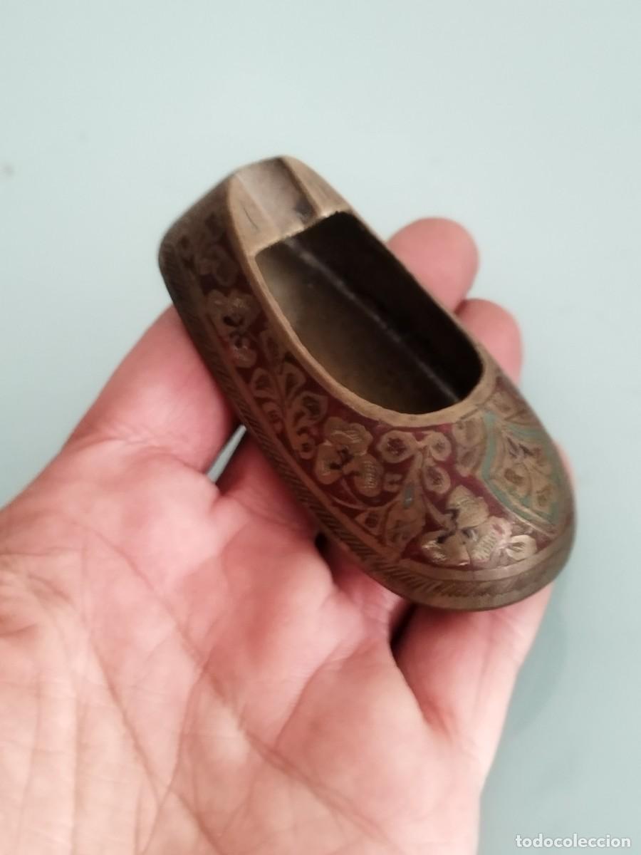 Ceniceros: Antiguo cenicero en forma de babucha, en bronce o lat&oacute;n cincelado.