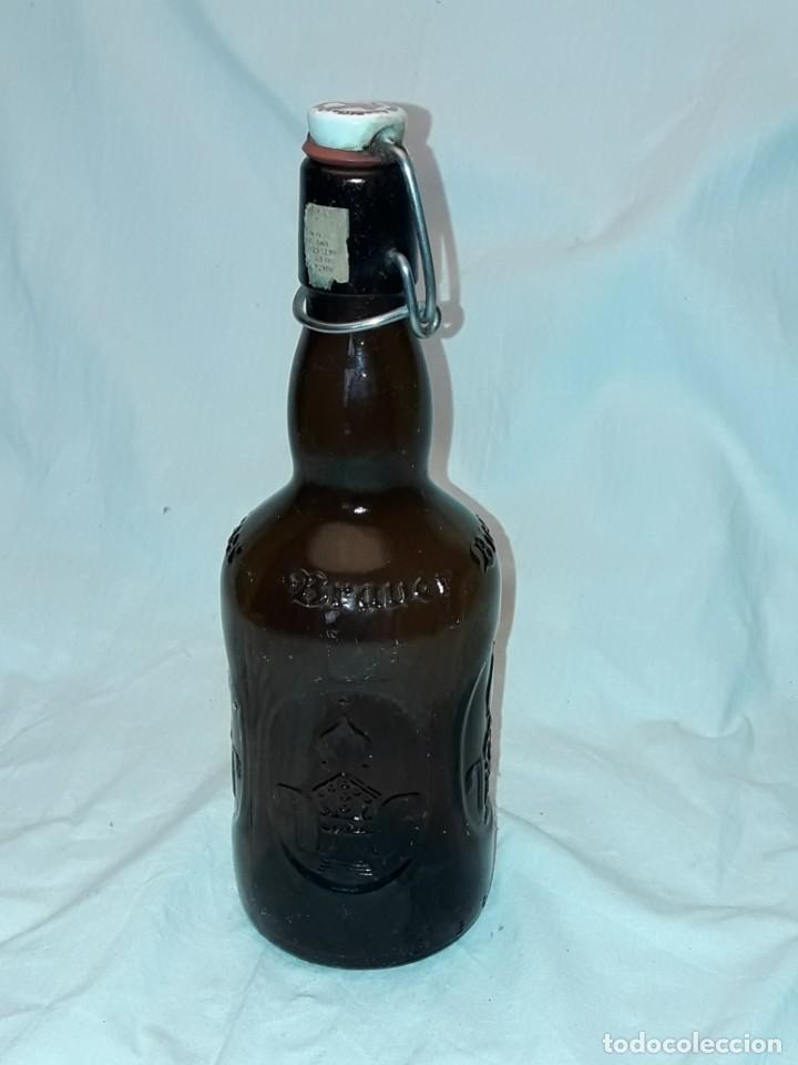Coleccionismo de cervezas: Bella botella de cristal con relieve cerveza alemana con tap&oacute;n articulado vac&iacute;a