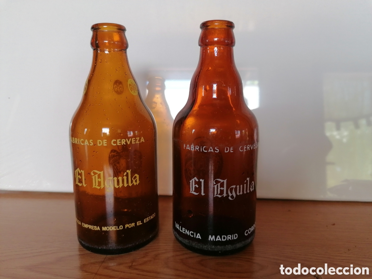 Coleccionismo de cervezas: Lote 2 antiguas botellas diferentes de cerveza EL &Aacute;GUILA. 33 CL.Regalo botellin Mahou.