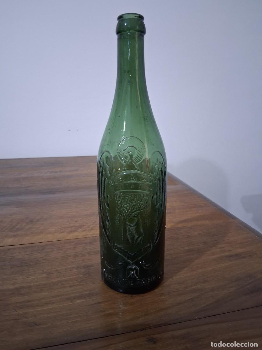 Coleccionismo de cervezas: Botella en relieve de cerveza El aguila 50 cl cristal verde claro