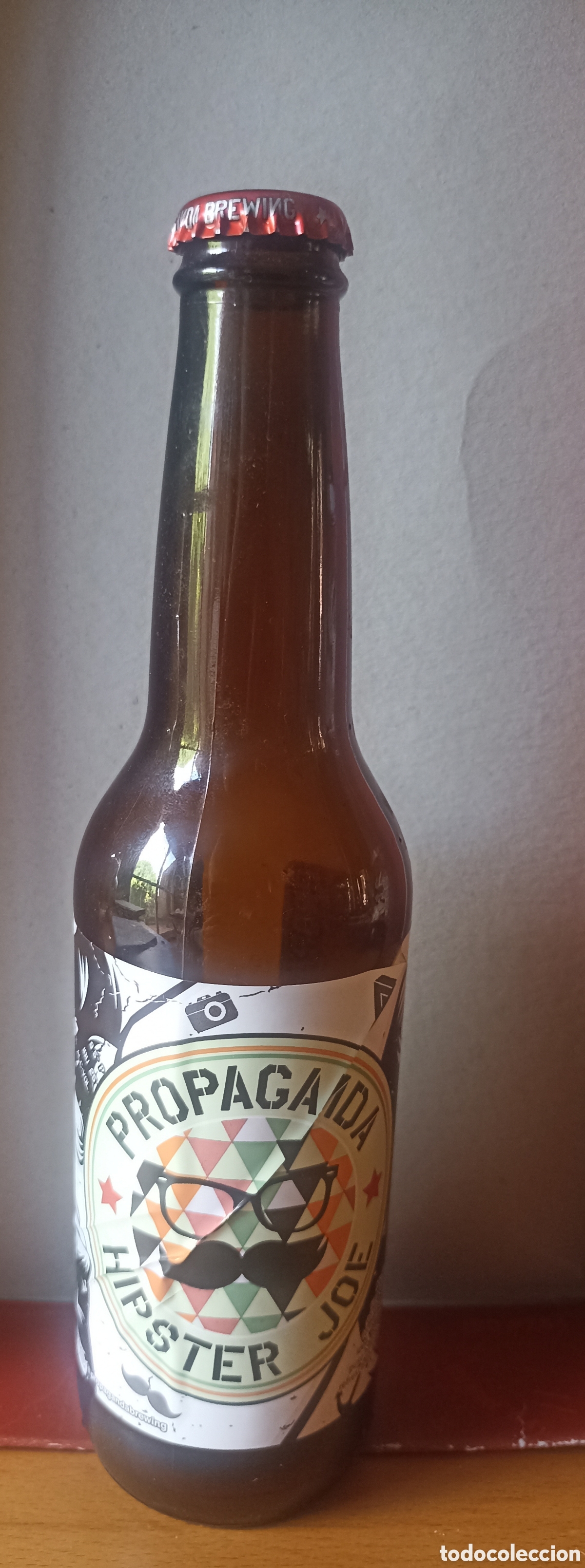 Coleccionismo de cervezas: Botella cerveza Propaganda Hipster Joe vac&iacute;a con chapa 355 ml
