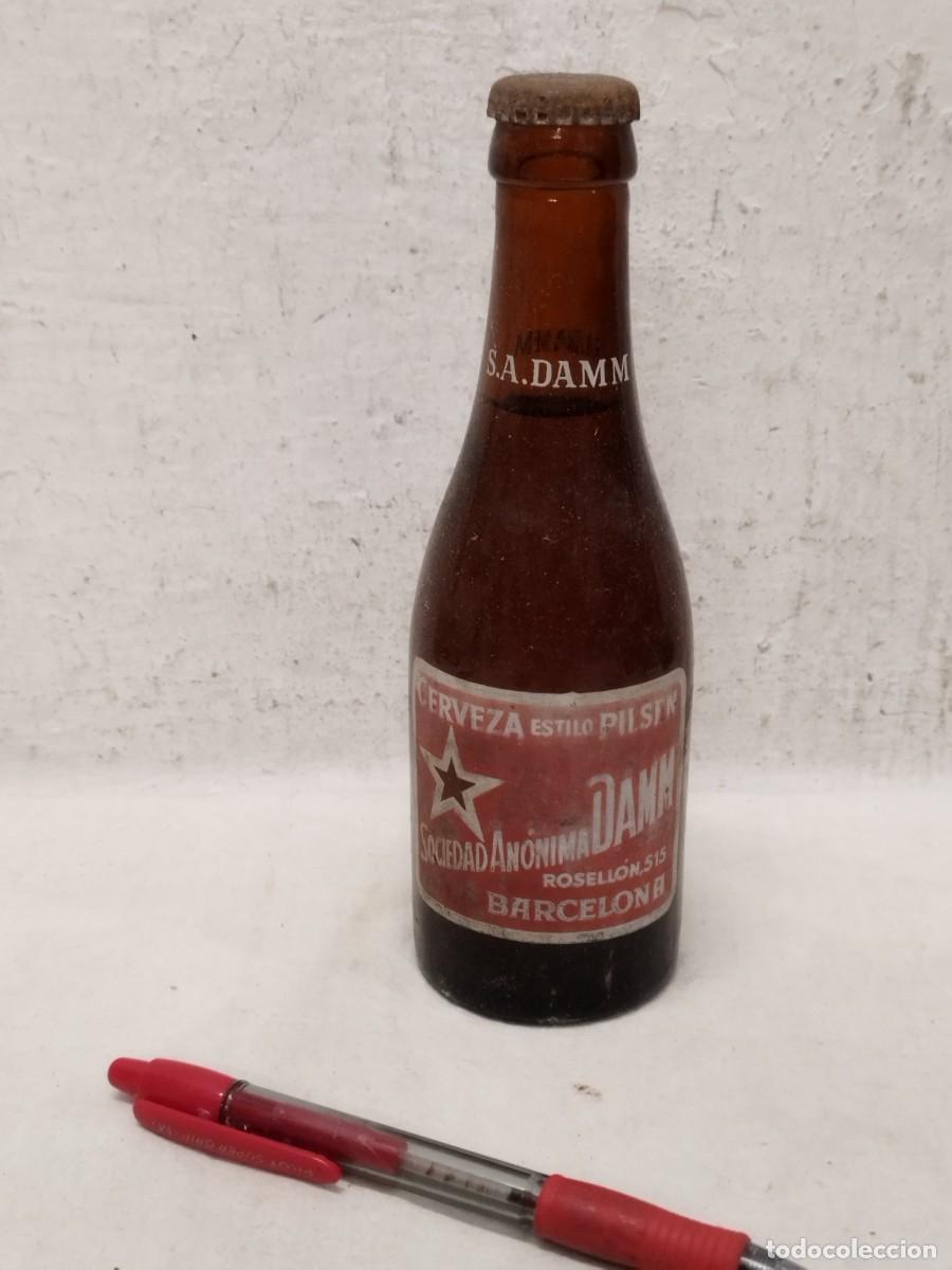 Coleccionismo de cervezas: Antigua botella de cerveza S.A. DAMM estilo pilsen. Rosell&oacute;n 515 Barcelona. Llena chapa original.