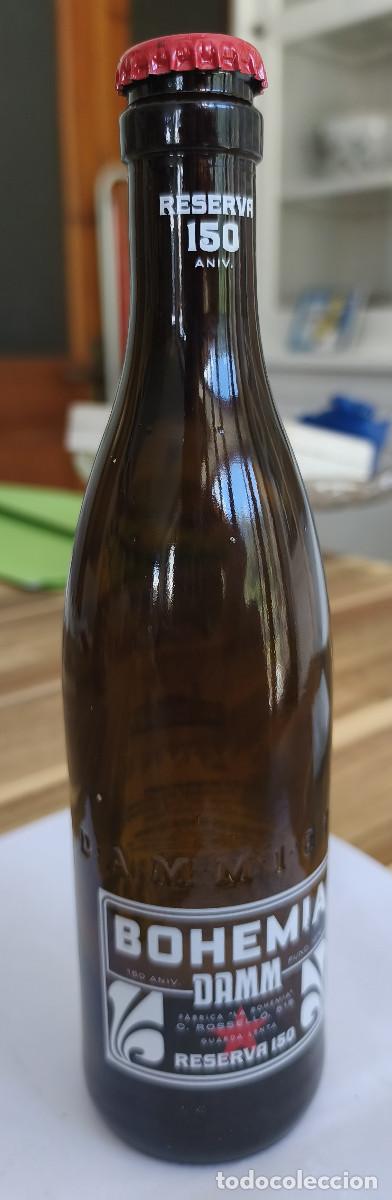 Collezionismo di birre: BOTELLA VACIA con Etiquetas y CHAPA TAP&Oacute;N CORONA - BOHEMIA DAMM 150 Aniversario - Barcelona