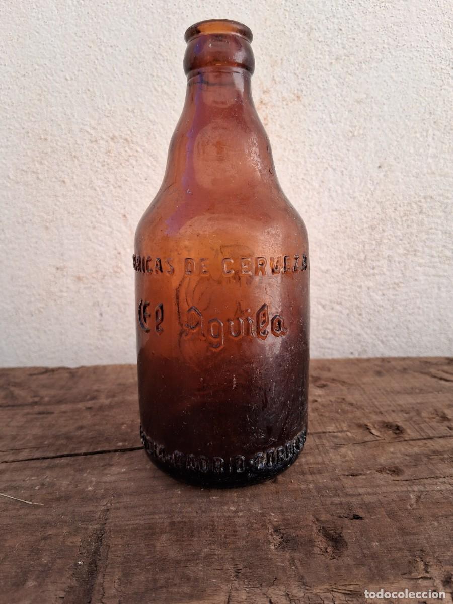 Coleccionismo de cervezas: Antigua botella de cerveza tercio El aguila letras en relieve