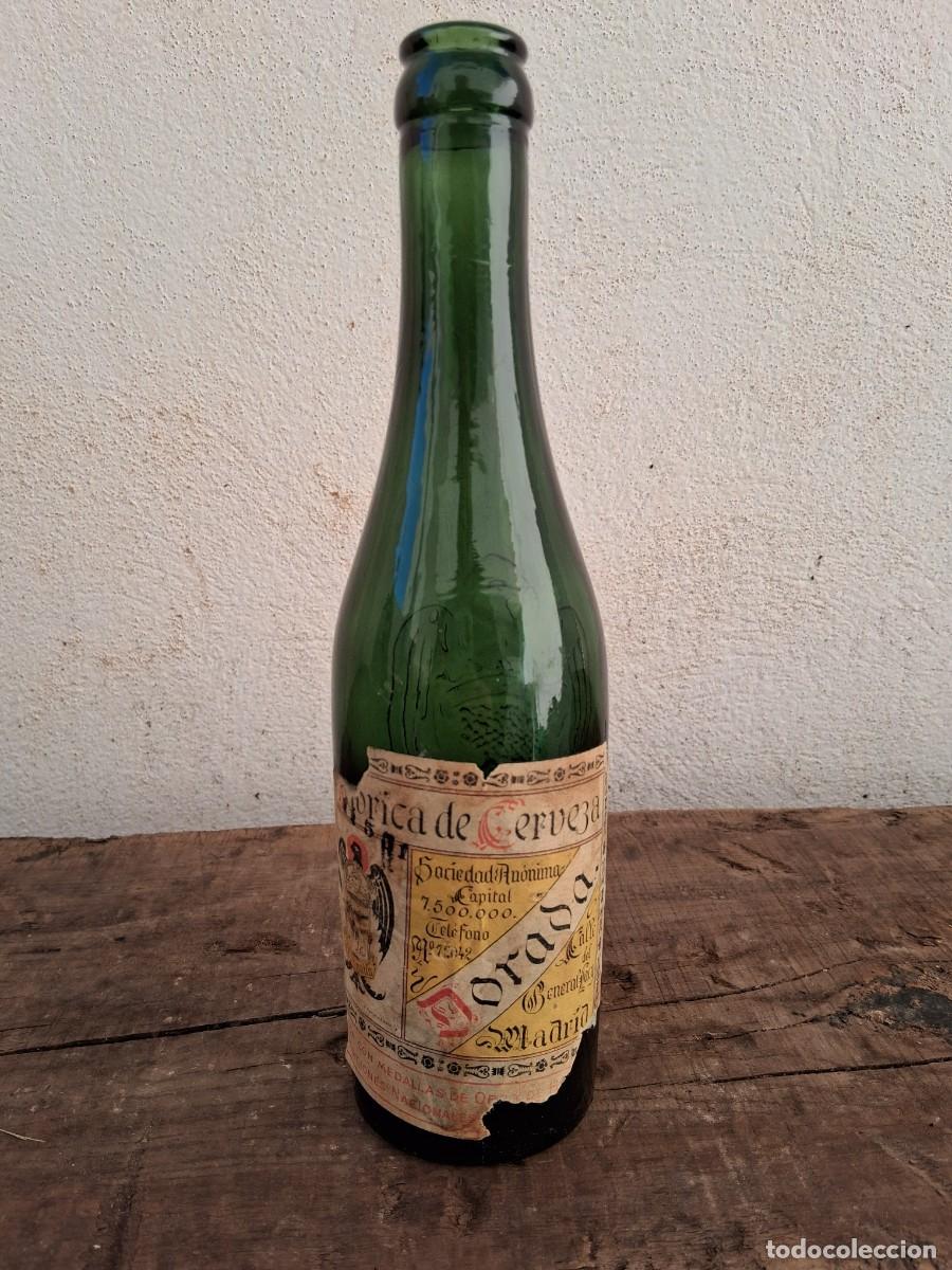 Coleccionismo de cervezas: Antigua botella de cerveza tercio El aguila letras en relieve con etiqueta