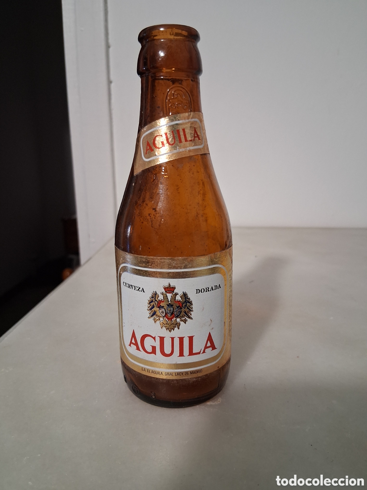 Coleccionismo de cervezas: Botella de cerveza El &aacute;guila dorada etiqueta y relieve 20 cl a&ntilde;o 1985