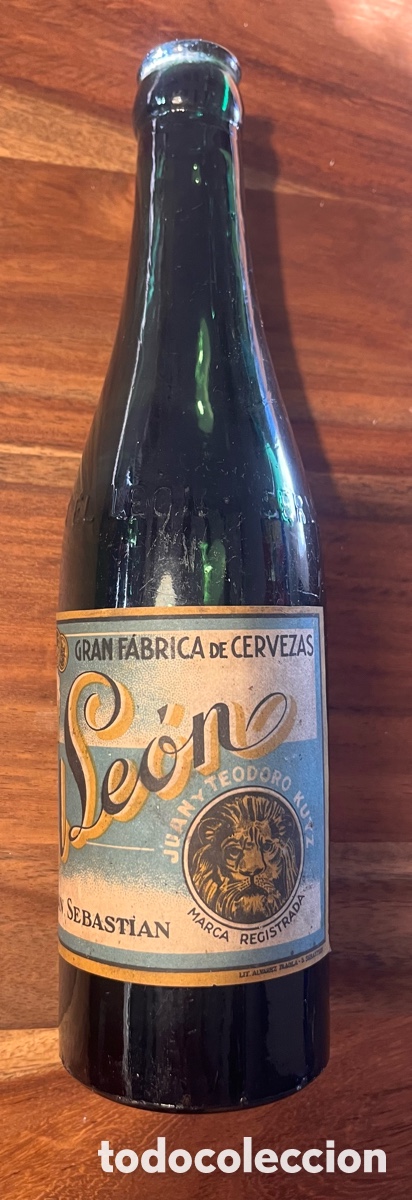 Coleccionismo de cervezas: Antigua botella cerveza el leon San Sebastian etiqueta papel y relieve