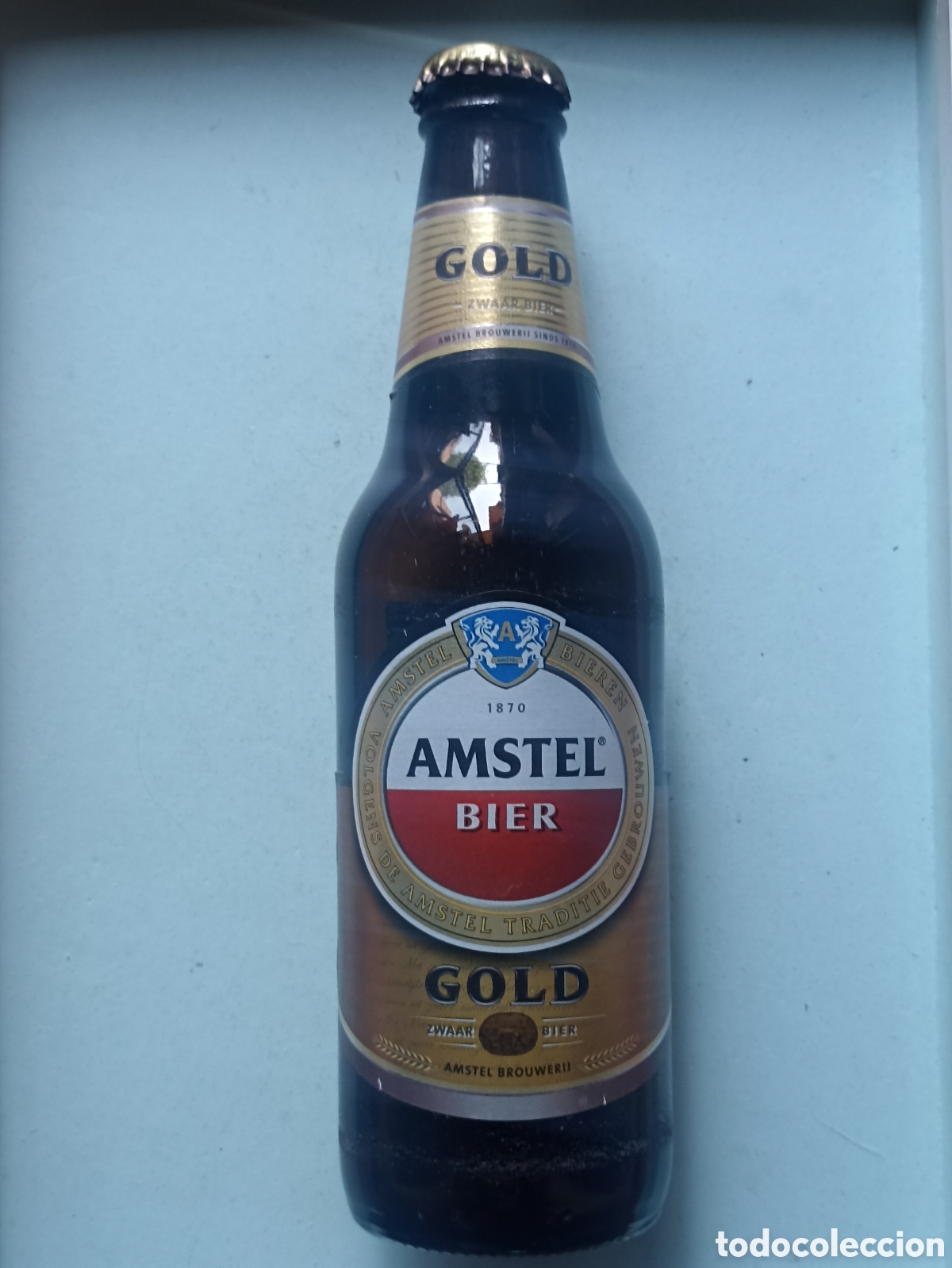Coleccionismo de cervezas: Botella cerveza Amstel Gold vac&iacute;a con chapa 300 ml