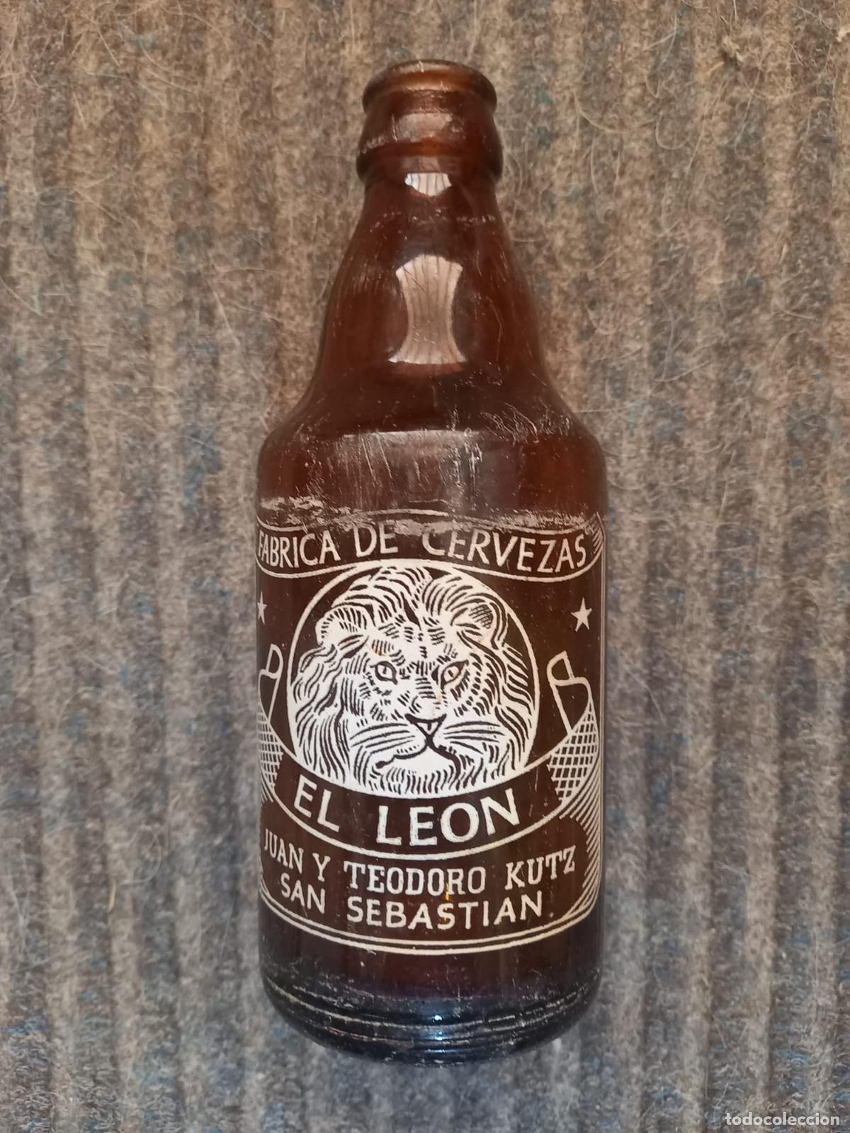 Coleccionismo de cervezas: Botella cerveza *EL LEON* TERCIO -MOD.2- SERIGRAFIA FONDO AMBAR, JUAN Y TEODORO KUTZ- SAN SEBASTIAN