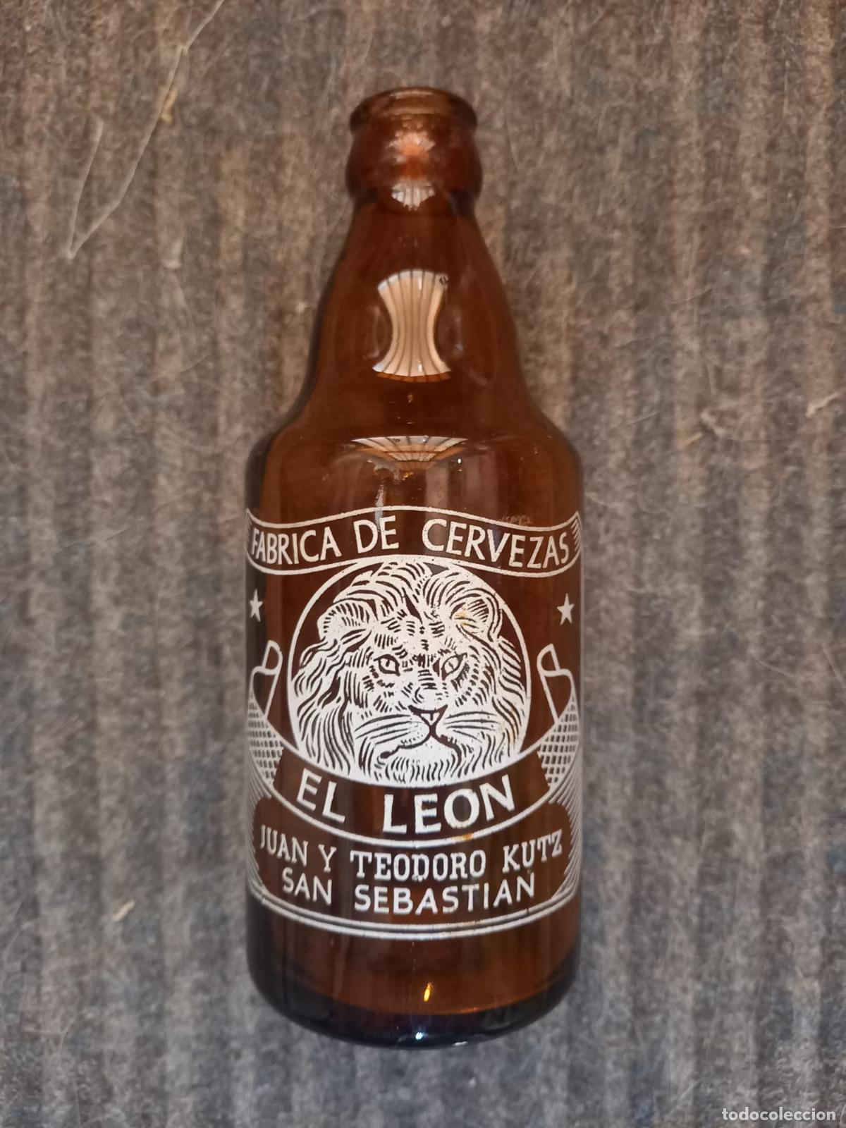 Coleccionismo de cervezas: Botella cerveza *EL LEON* TERCIO -MOD.2- SERIGRAFIA FONDO AMBAR, JUAN Y TEODORO KUTZ- SAN SEBASTIAN