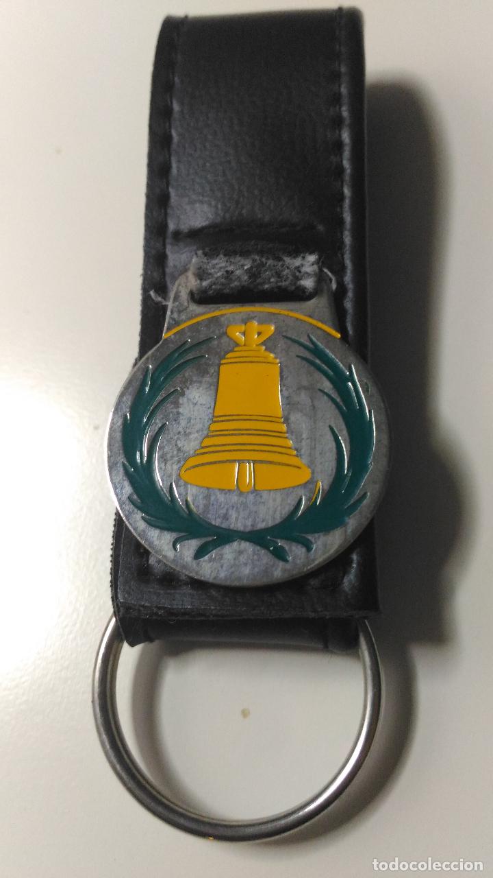 Sammlung von Schl&uuml;sselanh&auml;ngern: Llavero de piel y metal. Campana color amarillo y adornos de hojas.