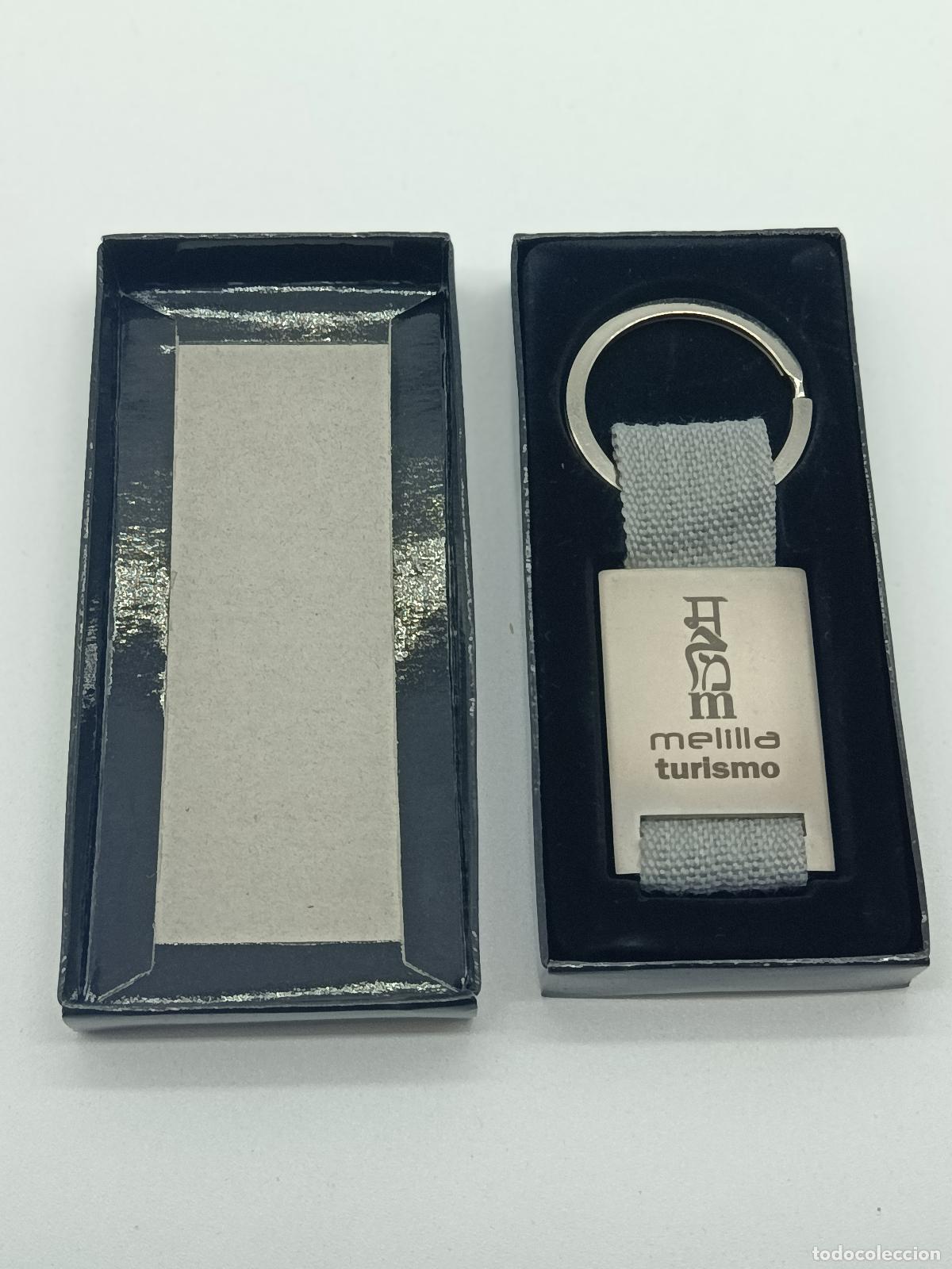 Coleccionismo de llaveros: LLAVERO MELILLA TURISMO SIN USO. METAL Y TELA GRIS. CAJA ORIGINAL.