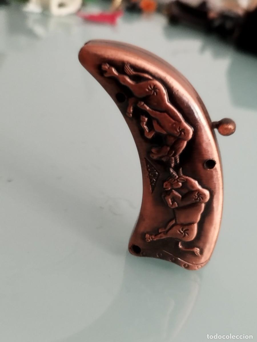 Mecheros: Mechero, encendedor forma de cuerno con relieves.