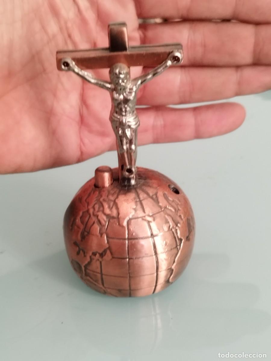Mecheros: Mechero forma crucifijo, cruz. Sobre una base esf&eacute;rica de metal cobrizo, representa globo terr&aacute;queo.