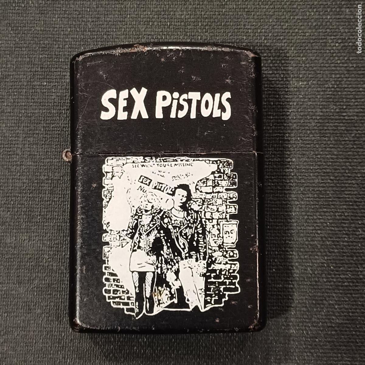 Mecheros: ENCENDEDOR GASOLINA SEX PISTOLS/TIPO ZIPPO.
