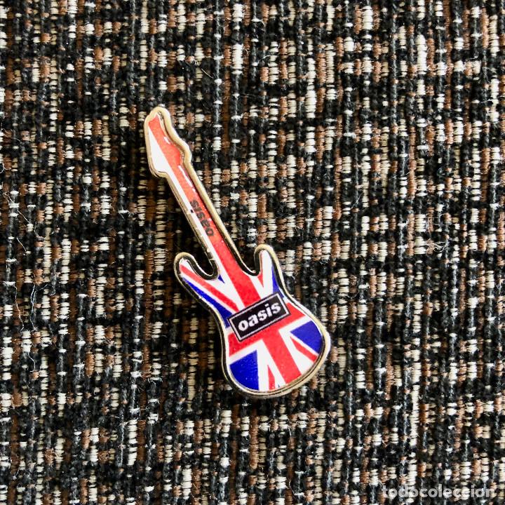 Pins de cole&ccedil;&atilde;o: PIN OASIS CON FORMA DE GUITARRA MET&Aacute;LICO Y RESINA CON DOBLE CIERRE MEDIDA 4 CENT&Iacute;METROS
