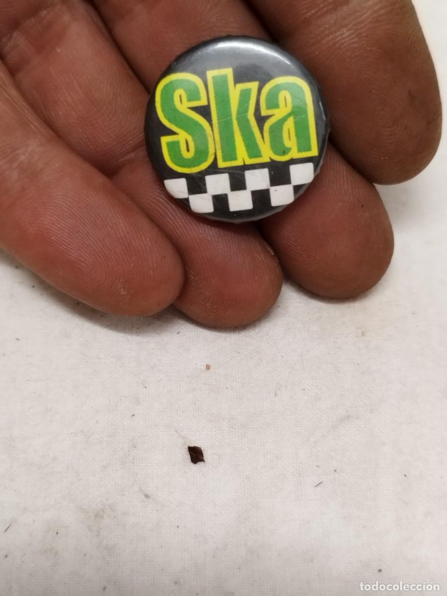 Pins de colecci&oacute;n: Chapa palabra &rdquo;Ska&rdquo; en letras grandes amarillas con borde verde sobre un fondo negro. Musica, reggae