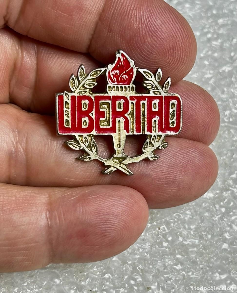 Pins de colecci&oacute;n: 3821.Pin antiguo con la palabra LIBERTAD en letras rojas prominentes sobre una antorcha