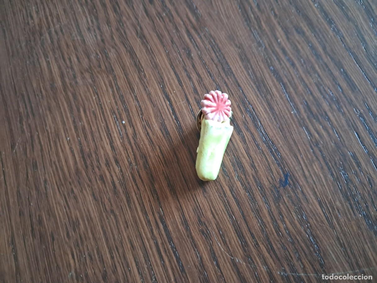 Collection pins: pin de resina o pl&aacute;stico, especie de jarr&oacute;n con una flor.