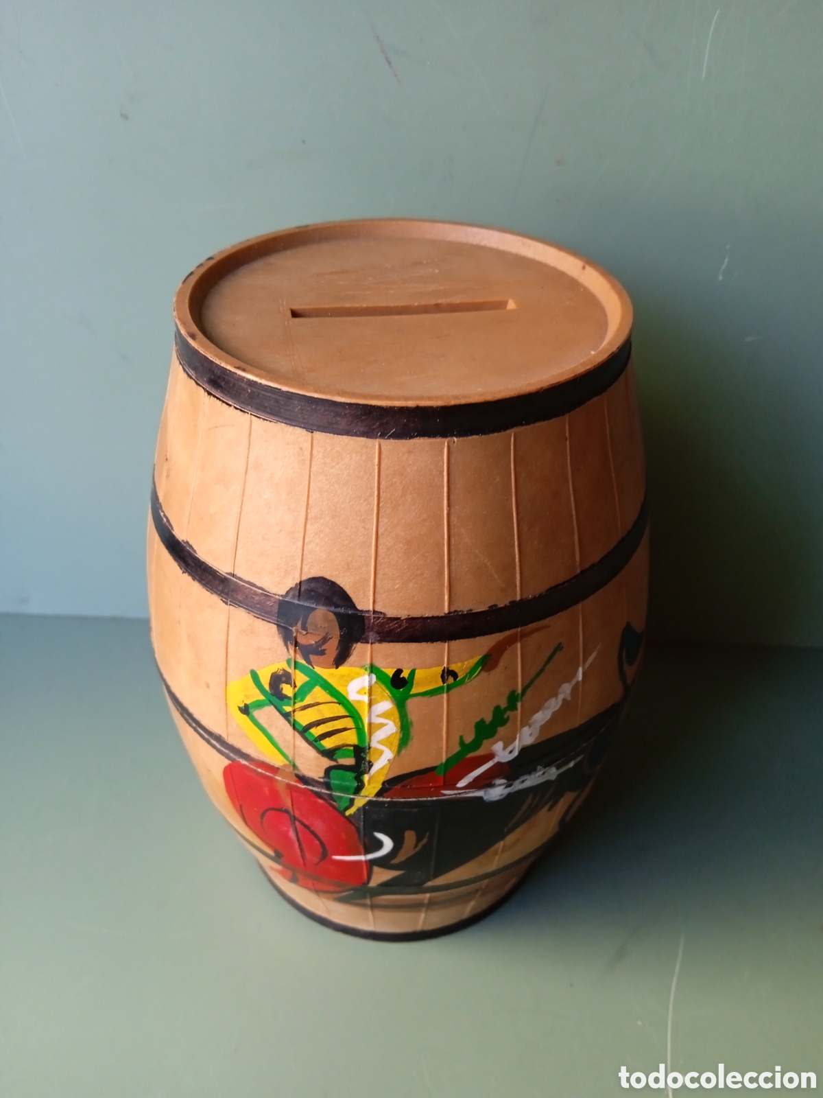 Tauromaquia: HUCHA DE PL&Aacute;STICO Y FORMA DE CUBA DECORADA CON MOTIV&Oacute; TAURINO - CON CLAVE- ALTO: 13cm.