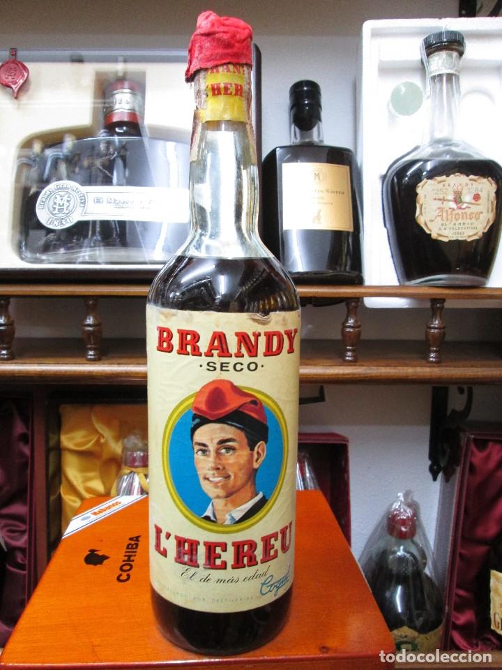 Coleccionismo de vinos y licores: ANTIGUA BOTELLA BRANDY CO&Ntilde;AC, L'HEREU SECO, EL DE M&Agrave;S EDAD IMPUESTO DE 80 CTS, DECADA 50-60