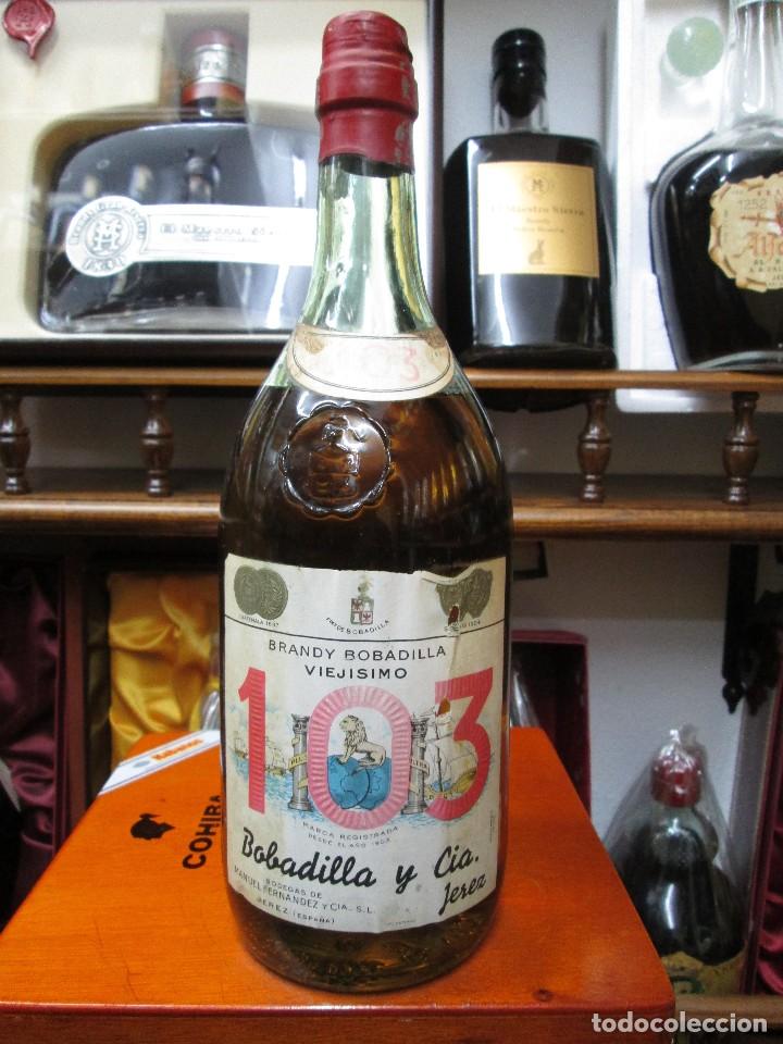 Coleccionismo de vinos y licores: ANTIGUA BOTELLA BRANDY CO&Ntilde;AC, 103 VIEJISIMO DE BOBADILLA Y CIA, IMPUESTO DE 80 CTS. DECADA 50-60