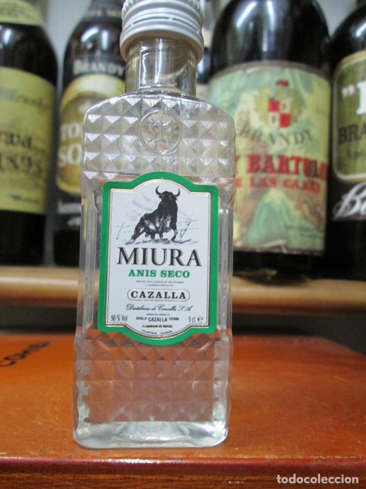 Coleccionismo de vinos y licores: ANTIGUO BOTELLIN BRANDY CO&Ntilde;AC, MIURA ANIS SECO, CAZALLA 12 CM ALTURA