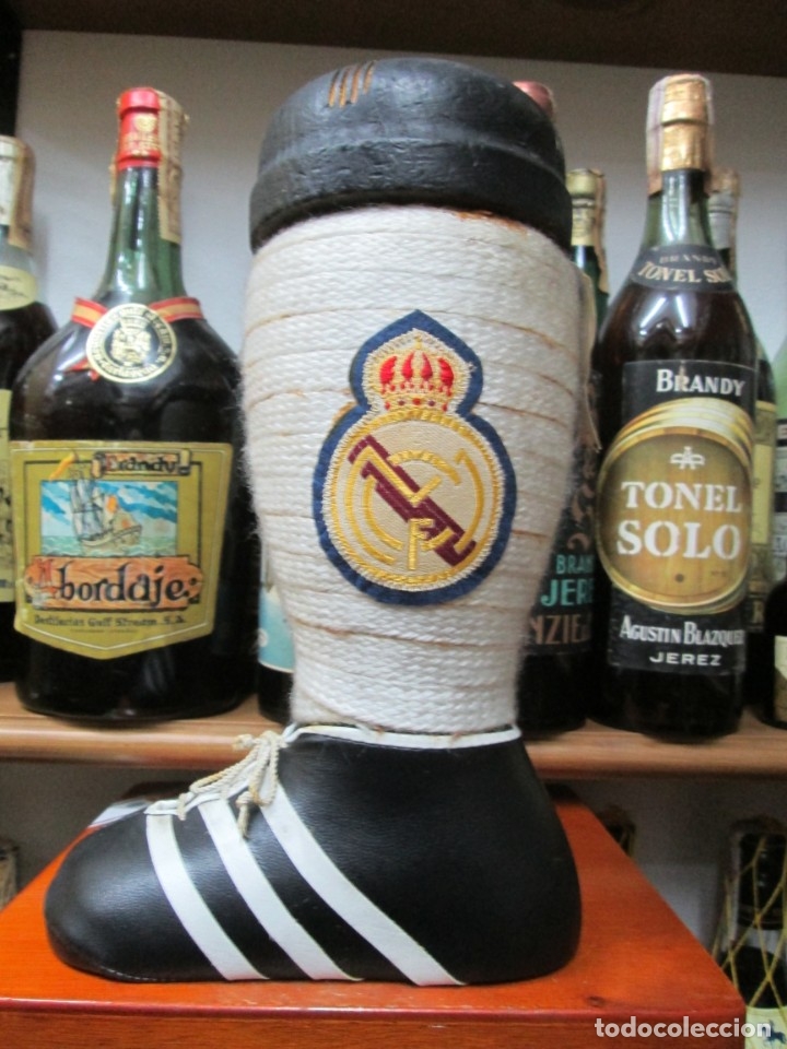 Coleccionismo de vinos y licores: ANTIGUA BOTELLA BRANDY CO&Ntilde;AC,BRANDY BOTA DE FUTBOL, REAL MADRID IMPUESTO DE 4 PTS. DECADA 60-70