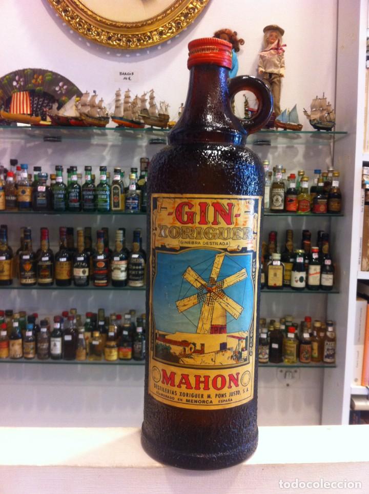 Sammlung von Weinen und Lik&ouml;ren: BOTELLA DE VIDRIO. LLENA. GIN XORIGUER, GINEBRA DESTILADA. MAH&Oacute;N, MENORCA. 1000 CC, TAP&Oacute;N MET&Aacute;LICO