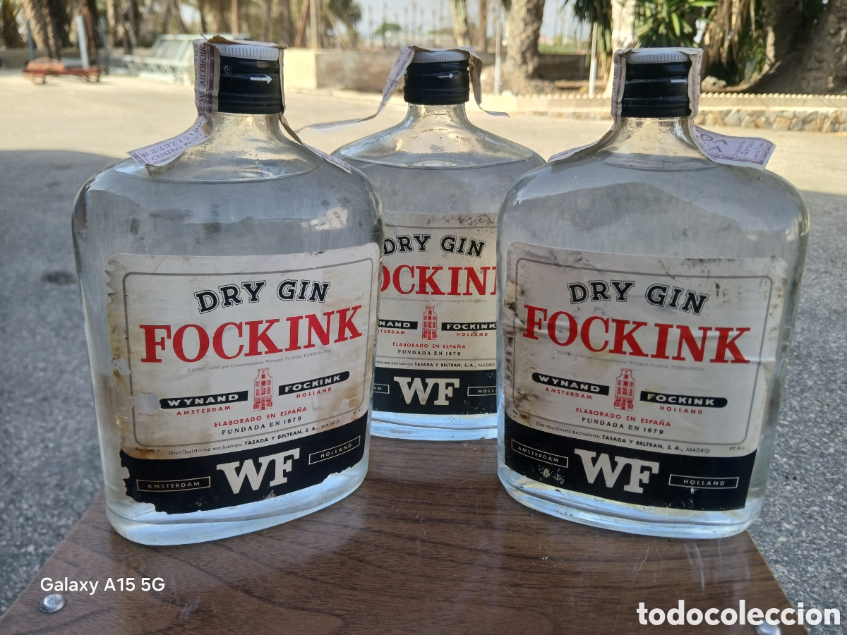 Collection of wines and liquors: TRES BOTELLAS PETACA DRY GIN FOCKINK WYNAND AMSTERDAM TASADA Y BELTRAN MADRID Y TARRAGONA * LLENAS *