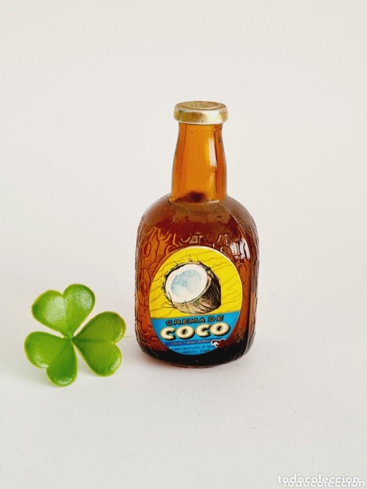 Coleccionismo de vinos y licores: BOTELLITA CREMA DE COCO 8.8CM VIDRIO BOTELLIN