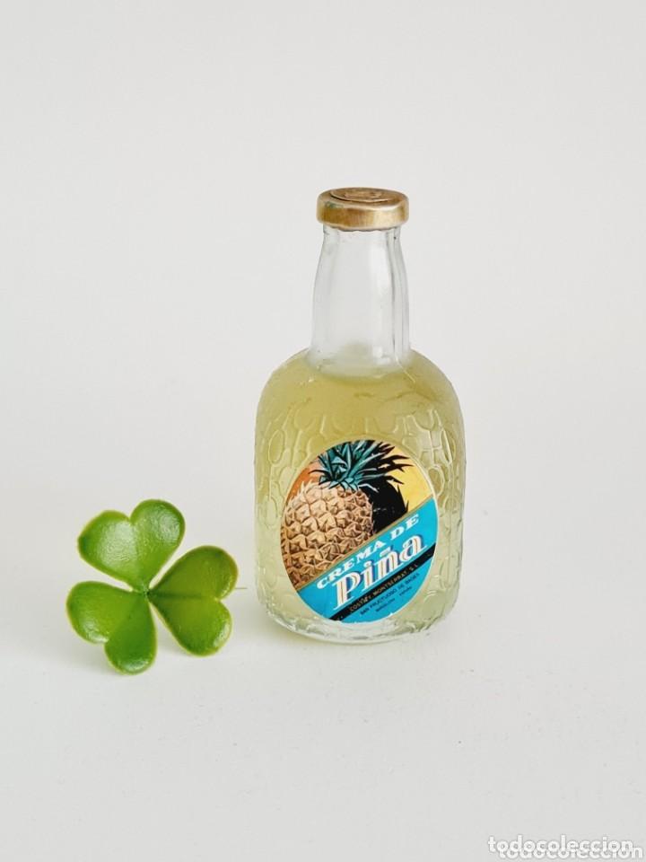 Coleccionismo de vinos y licores: BOTELLITA CREMA DE PI&Ntilde;A 8.8CM VIDRIO BOTELLIN