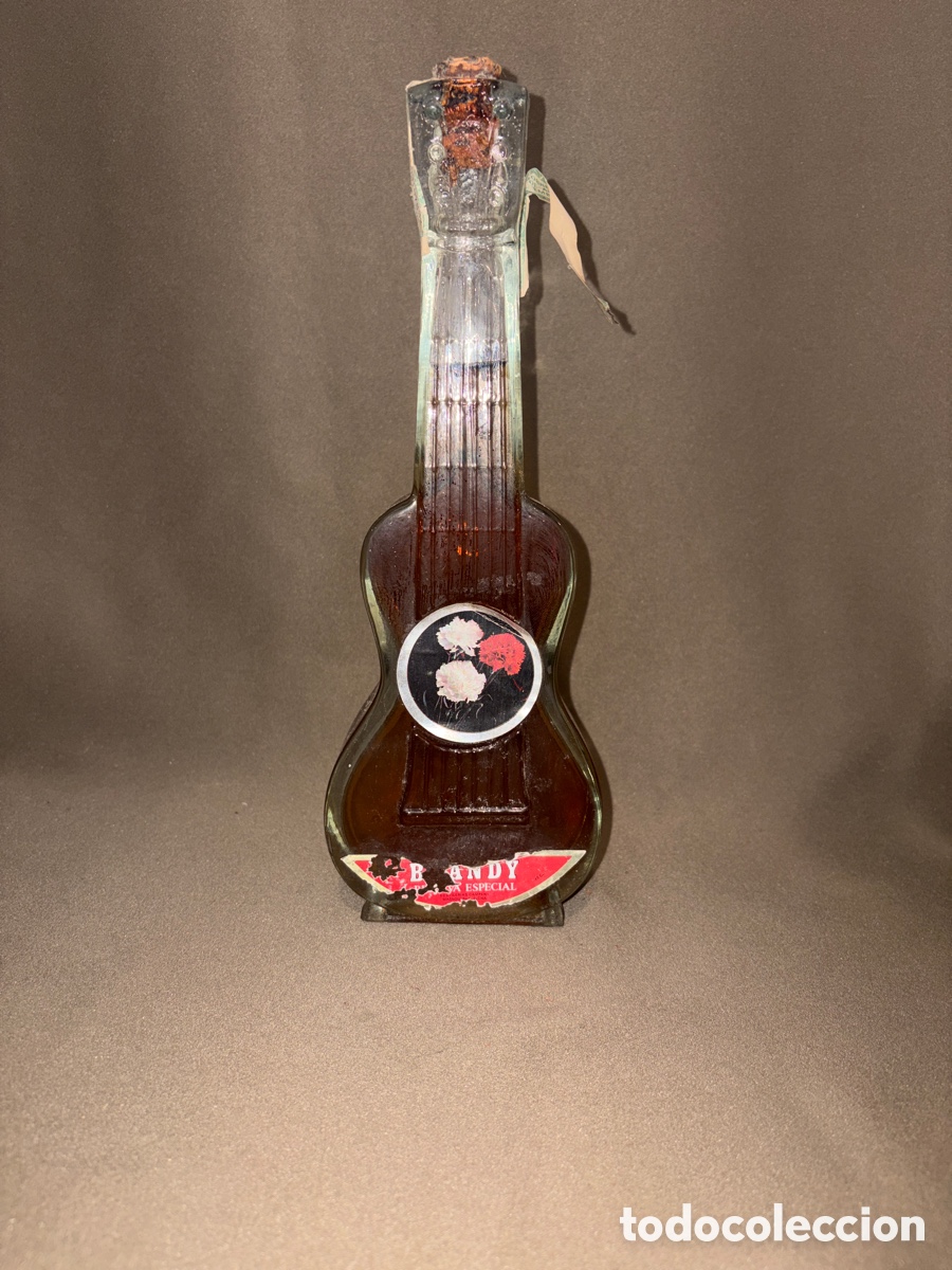 Coleccionismo de vinos y licores: Vintage botella de Brandy llena, forma de guitarra, Destilerias Campeny, Masnou.28x13cm