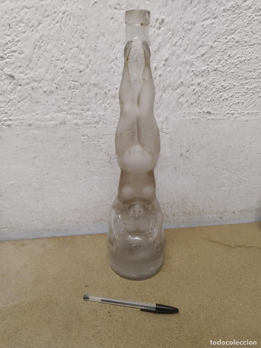 Coleccionismo de vinos y licores: Antigua botella de vidrio L'Acrobate&rdquo; que representa a una mujer en equilibrio o haciendo el pino.
