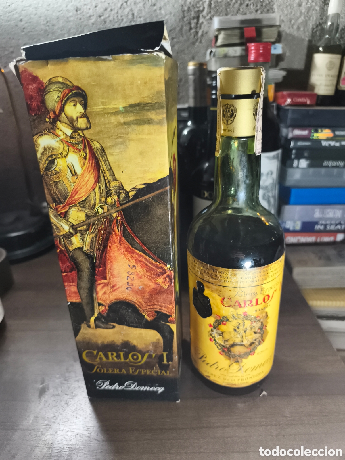 Coleccionismo de vinos y licores: Antigua botella de brandy Carlos I en su estuche, tiene algo de merma