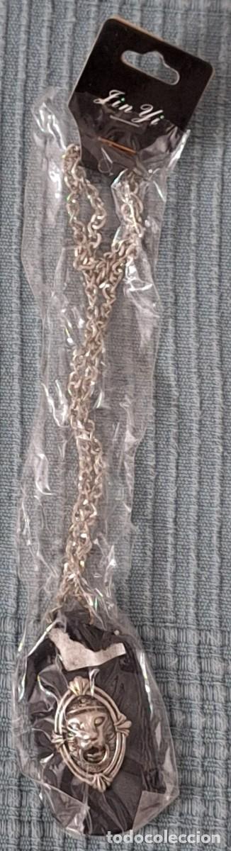 Coleccionismo: COLGANTE MET&Aacute;LICO CON CABEZA DE LE&Oacute;N EN RELIEVE SOBRE CUERO O MATERIAL SIMILAR