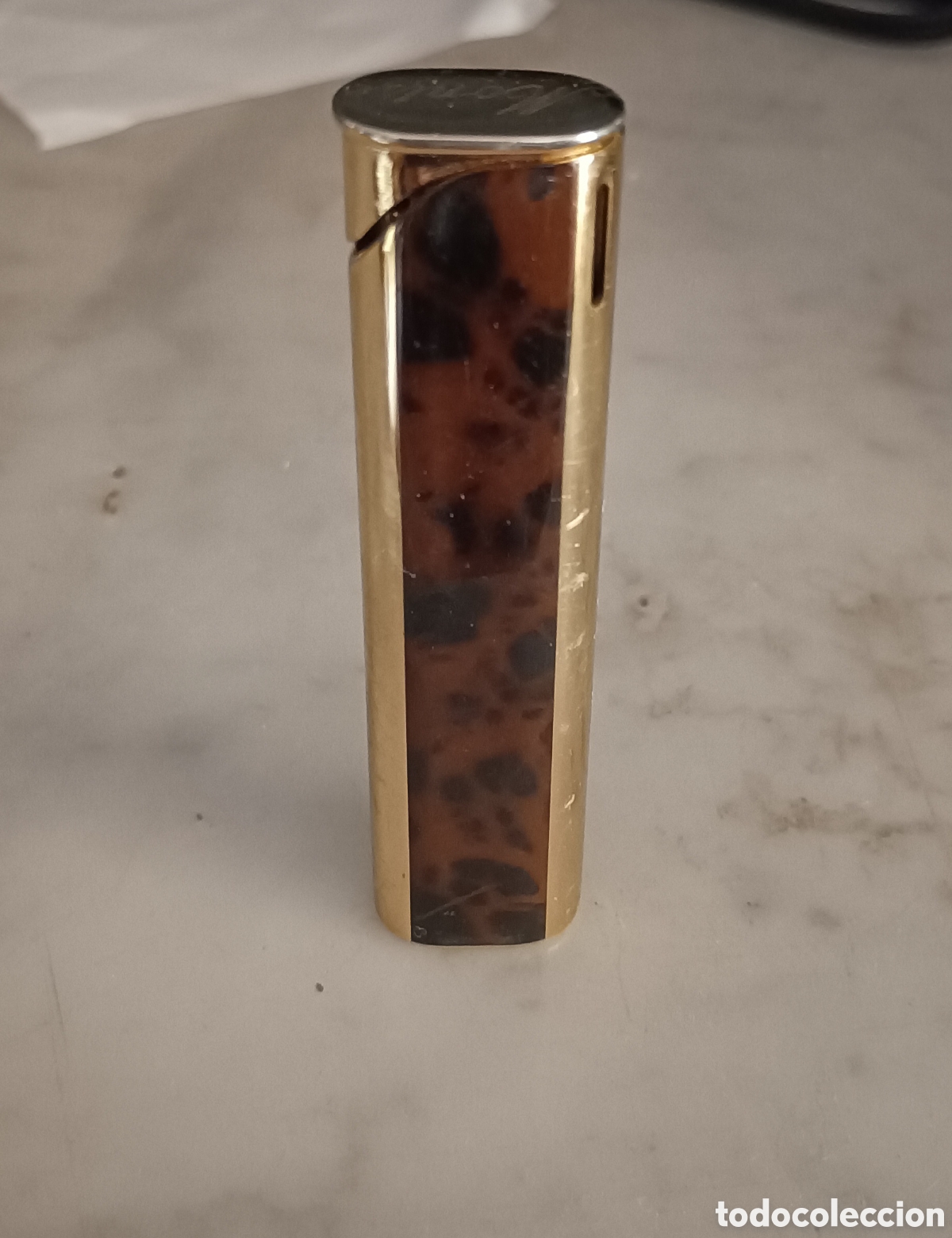 Collezionismo: Mechero encendedor Penguin de metal dorado y con esmalte marr&oacute;n con aguas.