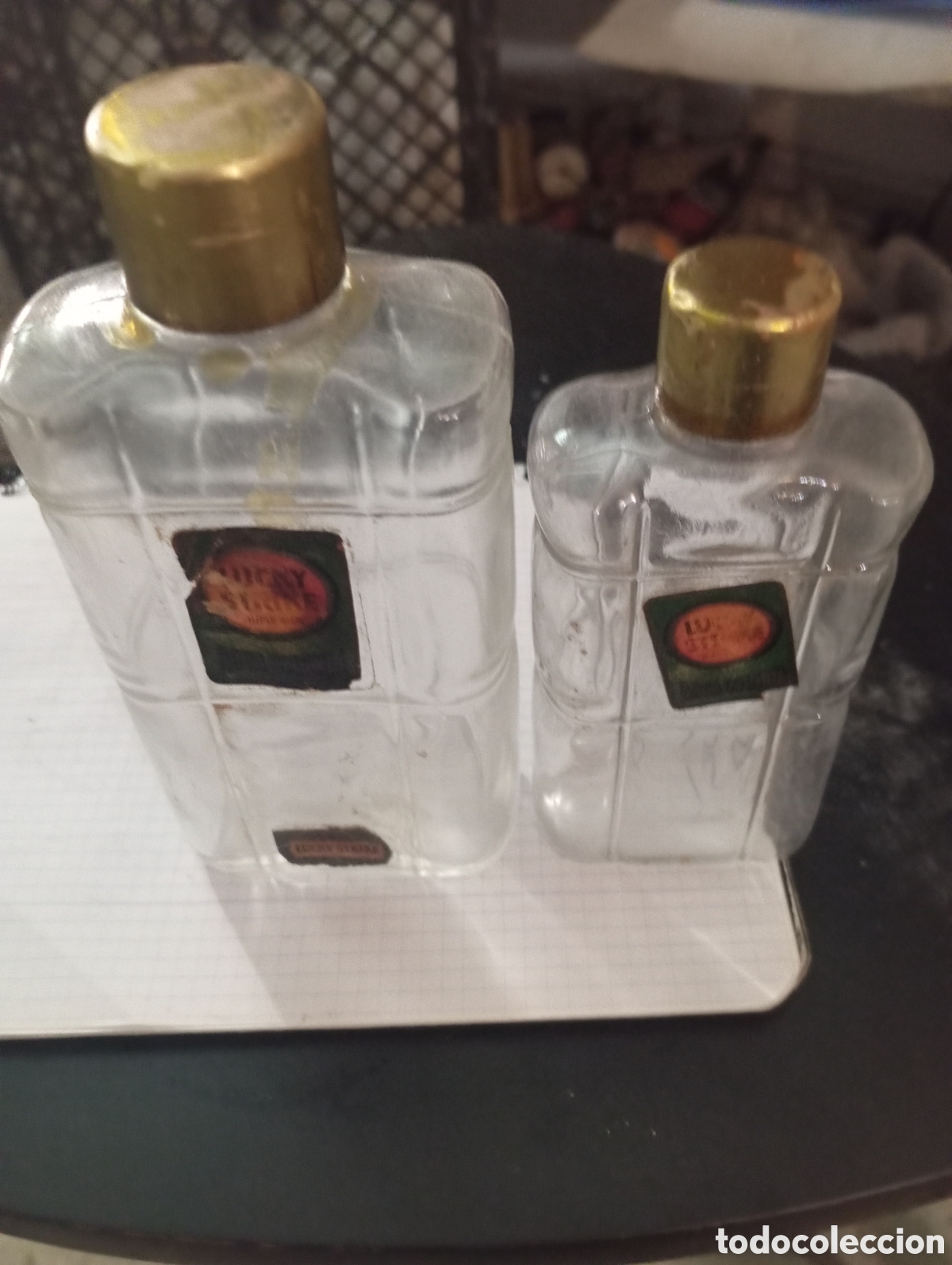 Coleccionismo: 2 botellas colonia Luky Strike e tama&ntilde;os crista con relieve a cuadros etiqueta 50-60 tap&oacute;n laton
