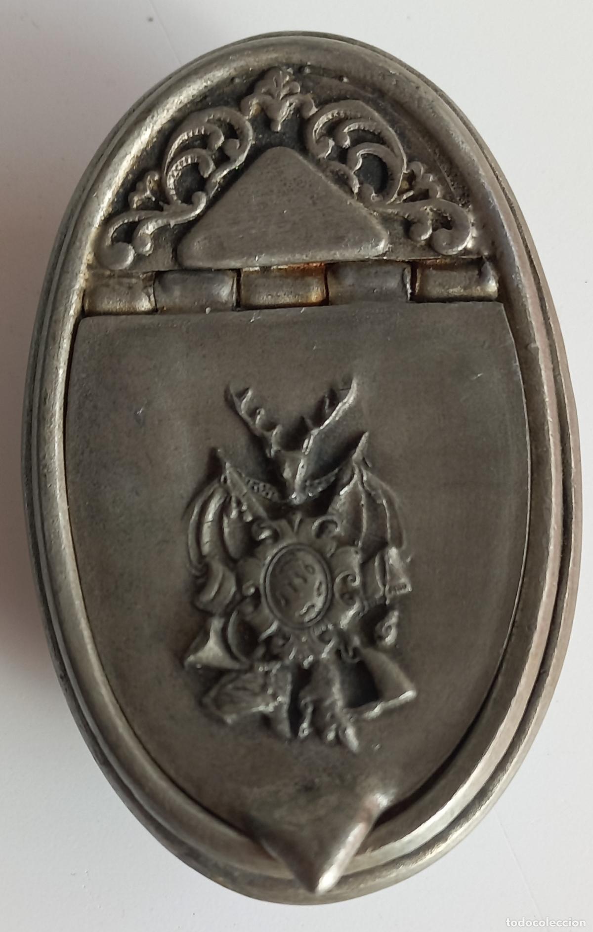 Coleccionismo: Antigua caja, tabaquera o pastillero de Zinc. Handrbeit, con escudo heraldico o de caza.