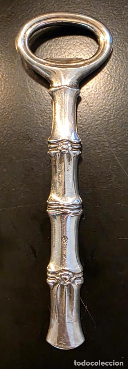 Coleccionismo: Abrebotellas Antiguo de Metal Plateado con Decoraci&oacute;n Estilo Bamb&uacute; y Monograma Grabado