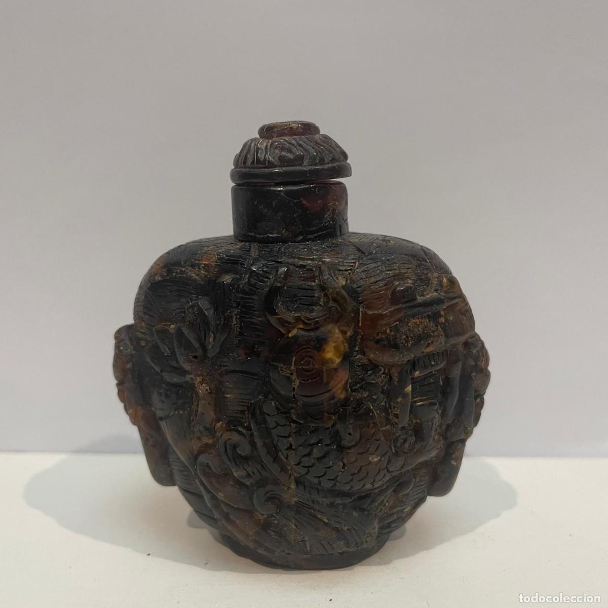 Coleccionismo: Botella de rap&eacute; china (snuff bottle) en &aacute;mbar con relieves decorativos, siglo XX