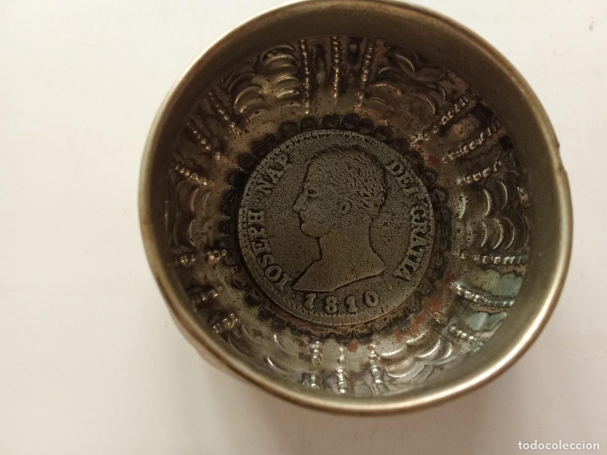 Collecting: Cuenco de alpaca repujado con motivos vegetales y moneda de Jose I (1810 20 R) 6 cm diametro x 3 cm