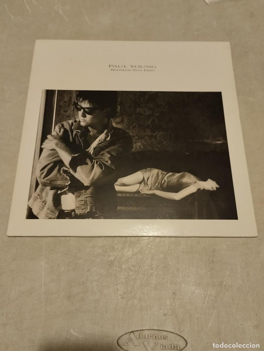 Discos de vinilo: Paul Young LP Between Two Fires Esp.1986 encarte letras - Foto 1