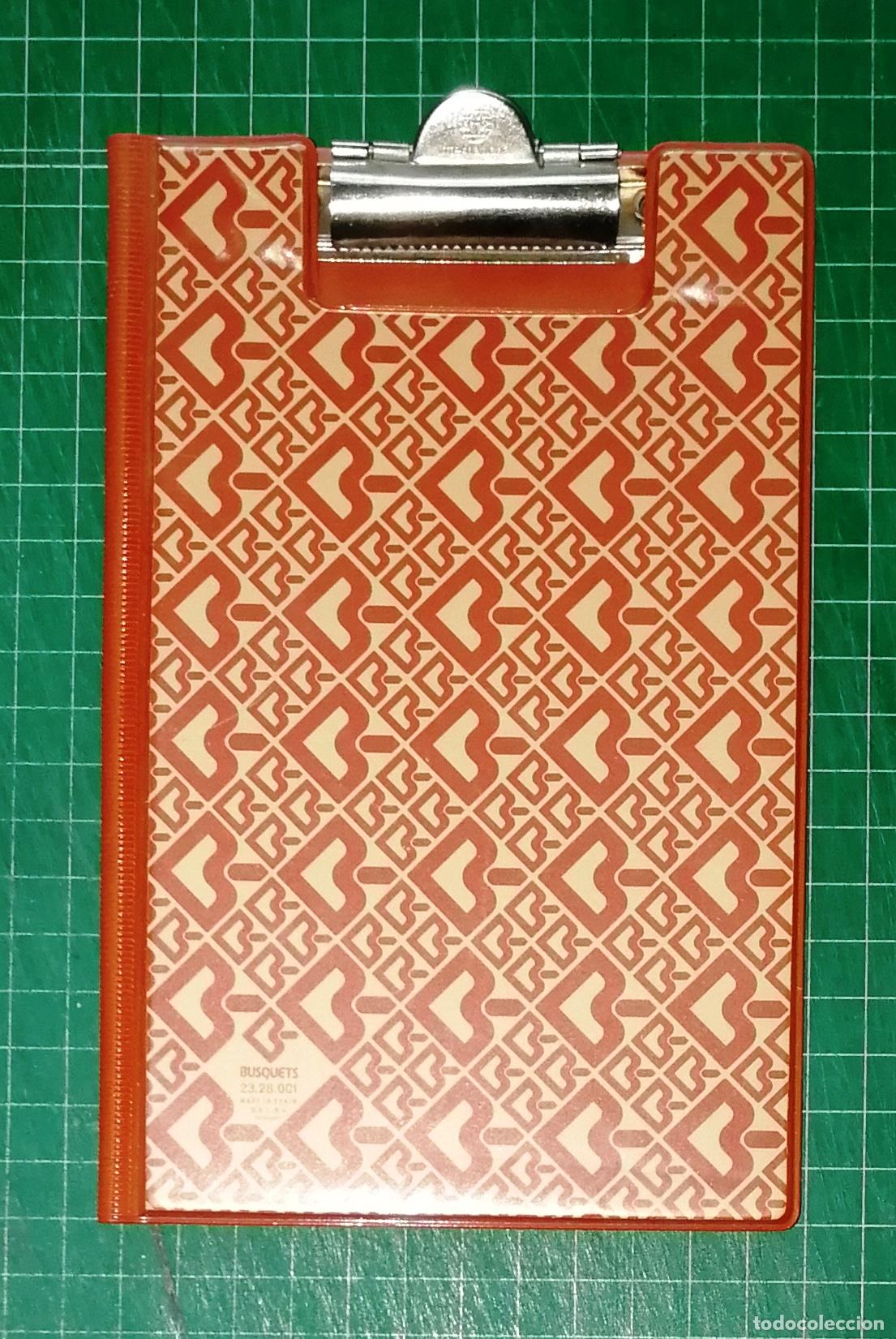 Escriban&iacute;a: CARPETA PL&Aacute;STICO CON PINZA CLIP METAL BUSQUETS. MARR&Oacute;N. LOGO. REF. 23.28.001. - 1981. - 19x12 cm